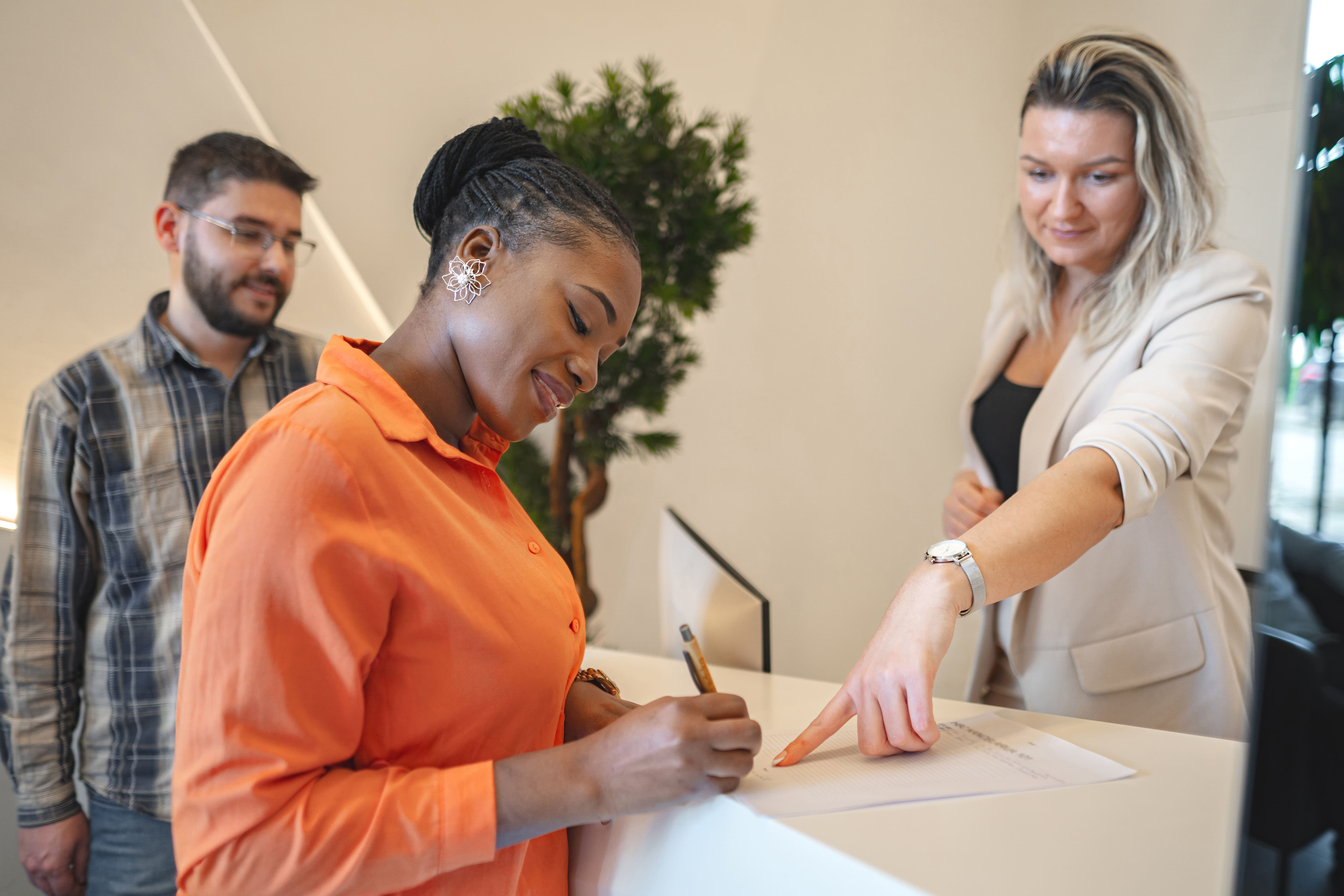 Woman Standing At Desk Signing Piece Of Paper 2025 04 13 22 48 55 Utc